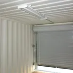 Interior of a shipping container looking out through an open rollup door