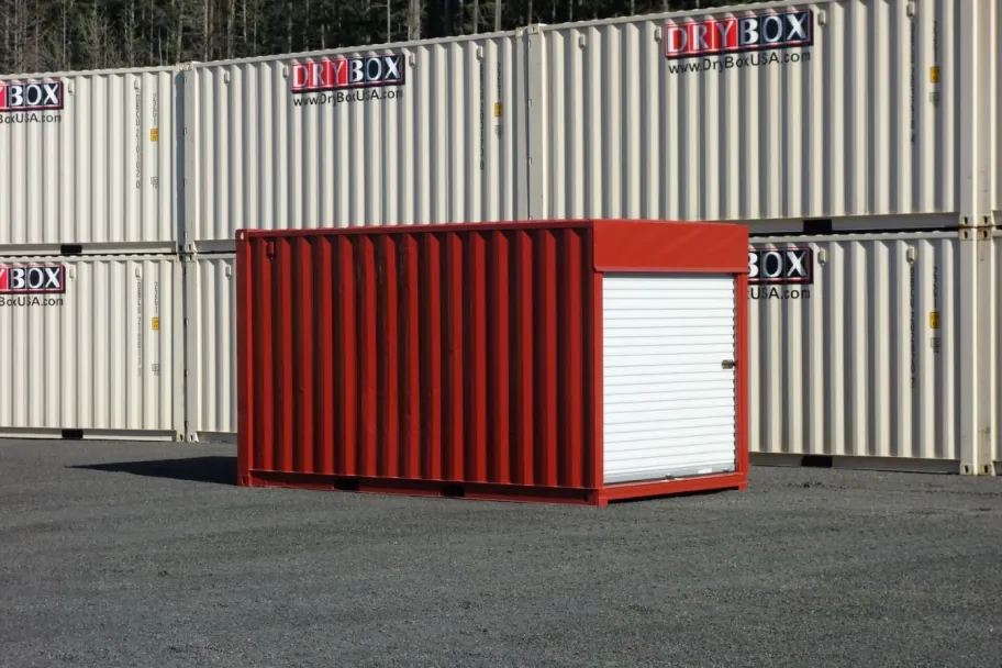 A red shipping container with a white roll-up door in a Dry Box yard