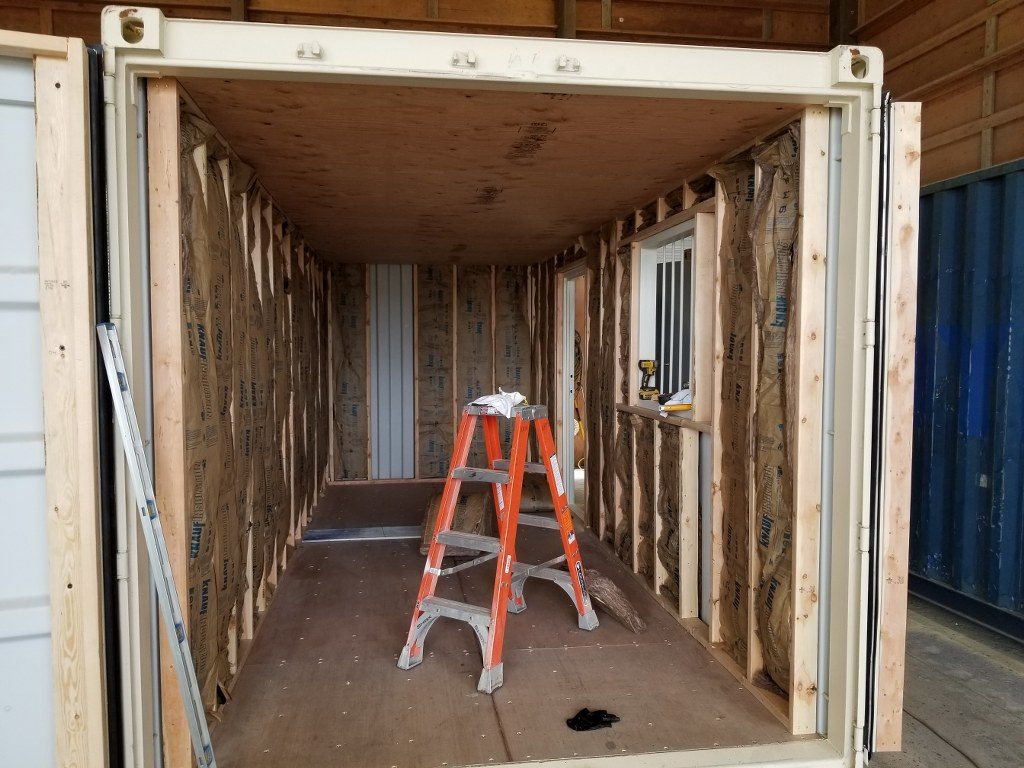 ladder set up in the middle of shipping container repairs