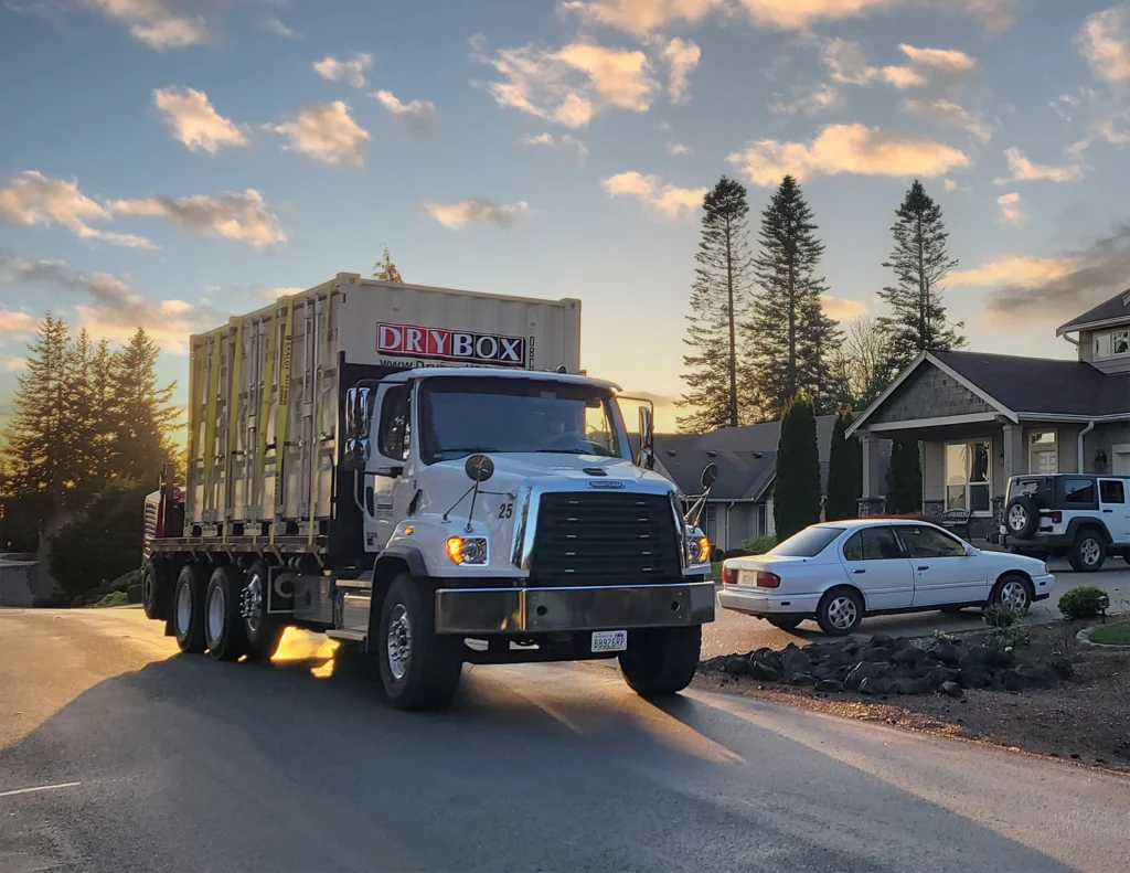 Three six-foot wide shipping containers are being delivered to a house