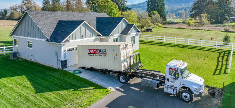 20ft moving container being delivered in a customer's driveway.