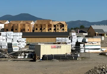 A ten-foot long, beige cargo container, at a construction site.
