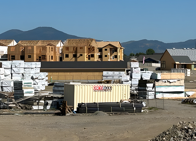 A ten-foot long, beige cargo container, at a construction site.